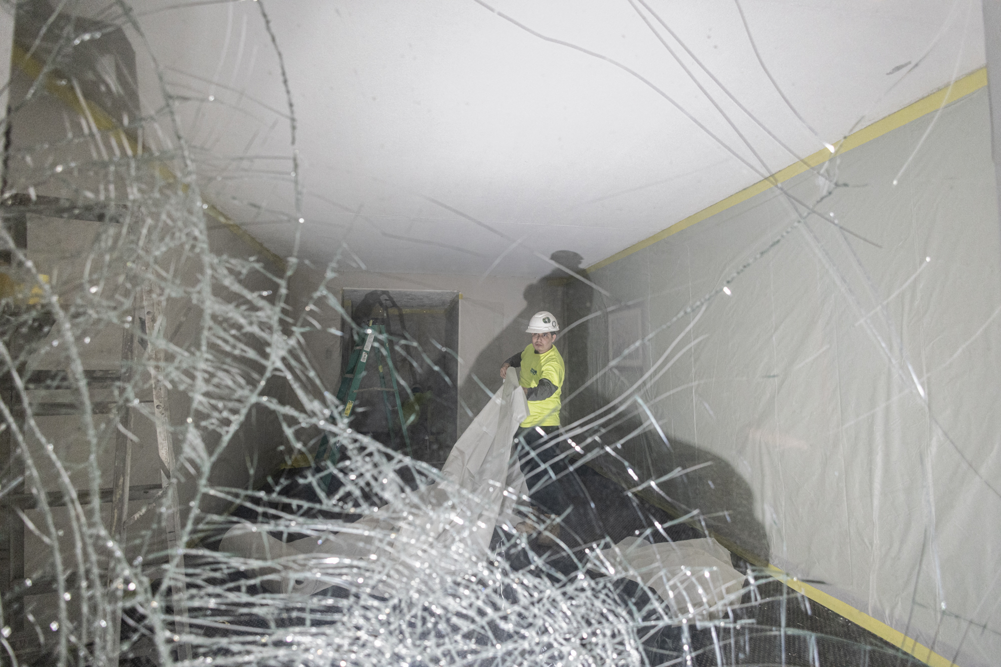 Worker behind shattered window glass during North Tower prep
